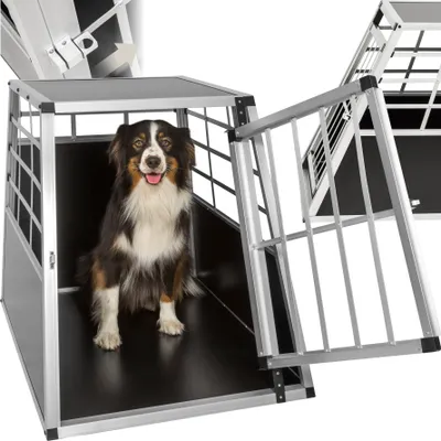 A dog is sitting inside a metal dog crate with the door open.