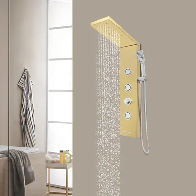 A gold shower panel with water flowing from the top and a handheld showerhead attached.