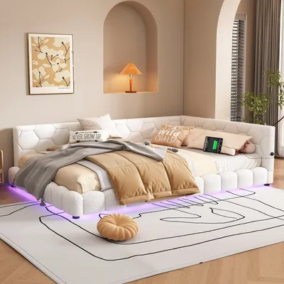 A modern bedroom with a white sectional bed featuring LED lighting, a rug, and a framed artwork on the wall.