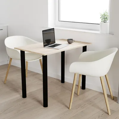 A small dining table with two chairs in a bright, minimalist room.