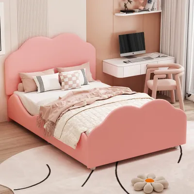 A pink bed with a cloud-shaped headboard and footboard, set in a bedroom with a desk and chair.