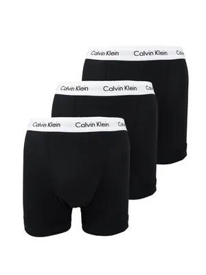 Three black Calvin Klein boxer briefs are arranged diagonally against a white background.
