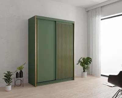 A green wardrobe with gold accents in a room with a large window and plants.