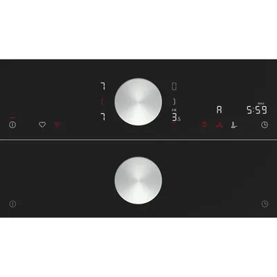 Close-up of a black appliance control panel with two silver rotary dials and a digital display.