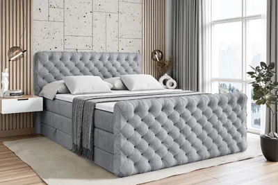A bedroom scene featuring a large, upholstered bed.