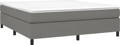 A studio shot of a box spring bed frame with a mattress on top, against a white background.