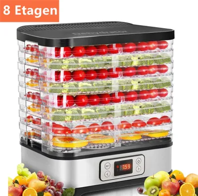 A multi-tiered food dehydrator filled with fruits and vegetables, displayed on a white background with a pile of fresh fruit in the foreground.