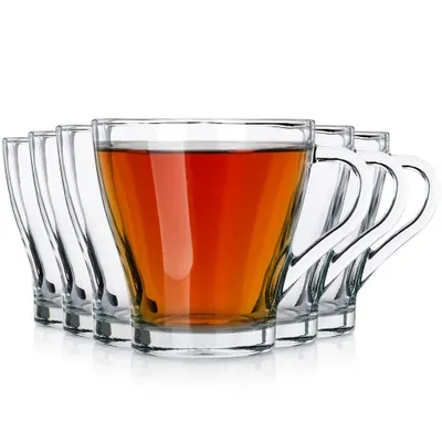 A set of clear glass cups, one filled with tea, arranged in a row against a white background.