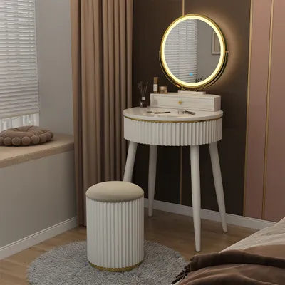 A vanity table with a mirror and stool in a bedroom setting.