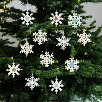 Snowflake ornaments hanging on a Christmas tree.