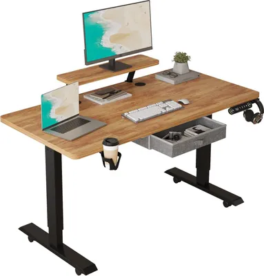 A standing desk setup with a monitor, laptop, keyboard, and accessories.