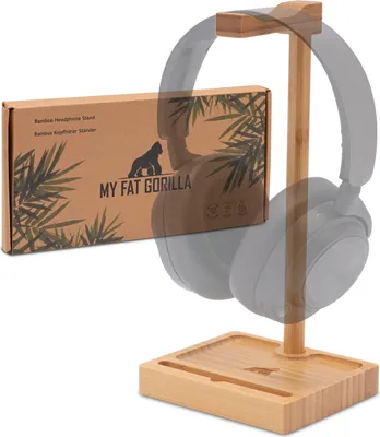 A bamboo headphone stand with a box and headphones.