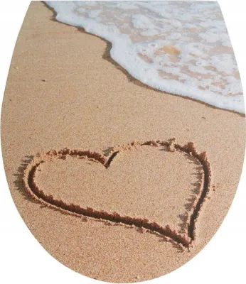 A heart drawn in the sand on a beach with a wave washing ashore.