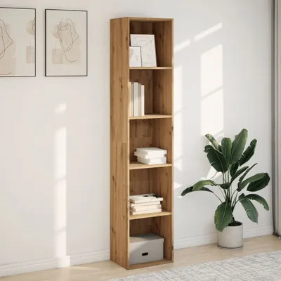 A tall, narrow bookshelf with several shelves, some of which contain books and decorative items, stands against a white wall with sunlight casting shadows. A large potted plant is to the right of the bookshelf.