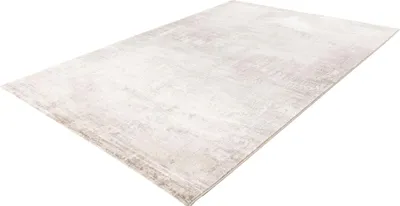 A modern, abstract patterned rug is shown from a diagonal angle against a white background.