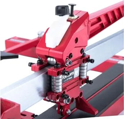 A close-up view of a red tile cutter with silver metal components.