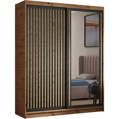A wardrobe with sliding doors, one of which is mirrored, reflecting a bedroom interior.