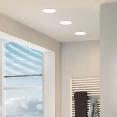 Recessed ceiling lights in a modern room with a window and a towel rack.