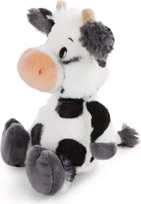 A plush toy cow sitting down against a white background.