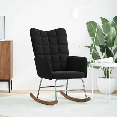 A black rocking chair in a well-lit room with a plant and a side table.
