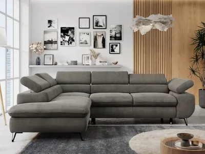 A modern living room with a sectional sofa, artwork on the wall, and decorative elements.