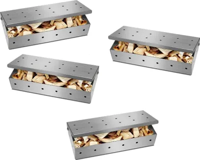 Four stainless steel smoker boxes filled with wood chips, arranged on a white background.