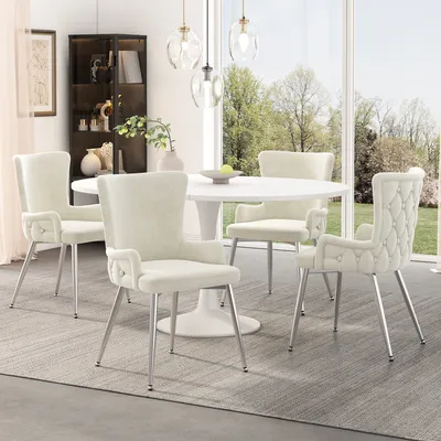 A set of beige dining chairs around a white tulip table in a well-lit dining room with a large window overlooking trees.