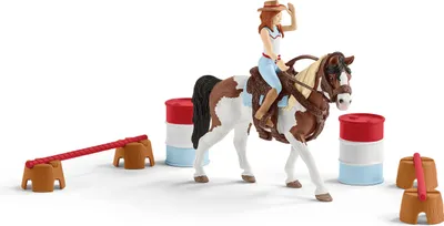 A toy horse and rider set with barrels and jump obstacles, arranged on a white background.