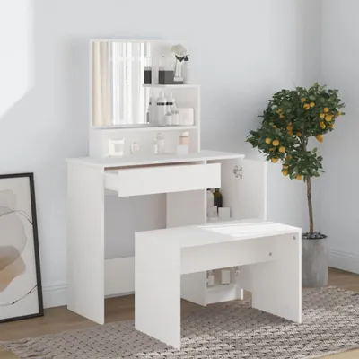 A white vanity table with a mirror and stool, set against a light gray wall with a potted plant to the side.
