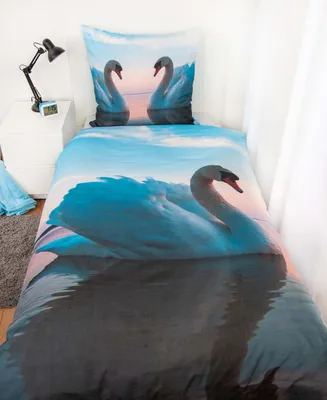 A bed with bedding featuring a swan print.