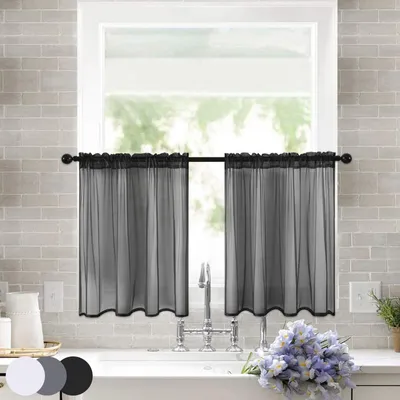 A kitchen sink area with black sheer bistro curtains hanging over the window.