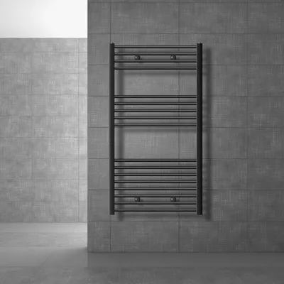 A dark anthracite radiator mounted on a textured gray tiled wall in a modern bathroom setting.