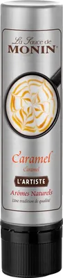 A bottle of Monin Caramel sauce with a close-up of caramel art on a drink.
