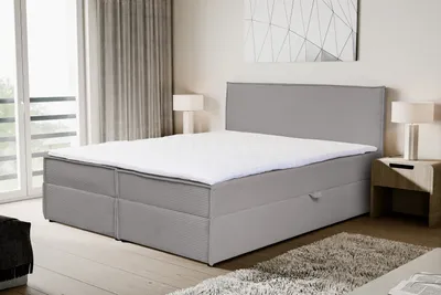 A modern bedroom setting with a large box spring bed.