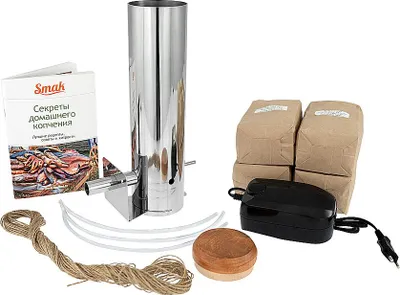 A collection of items for smoking food, including a smoker, bags of wood chips, a pump, and a booklet.