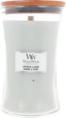 A large glass candle with a wooden lid and a light gray wax.