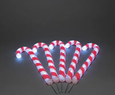 Five illuminated candy canes arranged in a fan shape on a dark gray background.