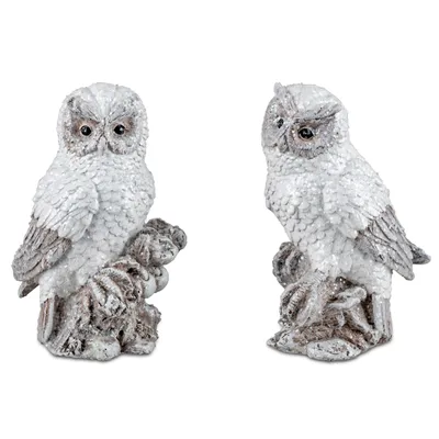 Two decorative owl figurines with a glittery, snowy appearance, placed on a white background.