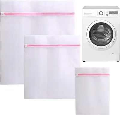 Three white mesh laundry bags with pink zippers are arranged in a group, with a white washing machine positioned to the right.