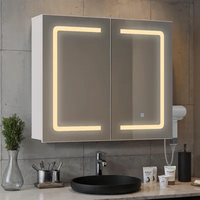 A bathroom vanity with a sink and a lighted medicine cabinet.