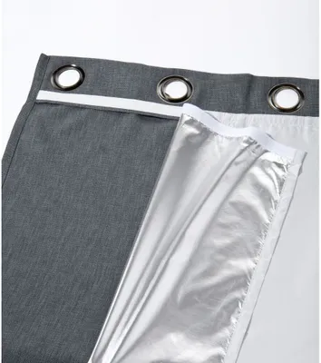 A close-up view of the edge of a gray curtain, showing its grommet holes and the silver thermal lining.