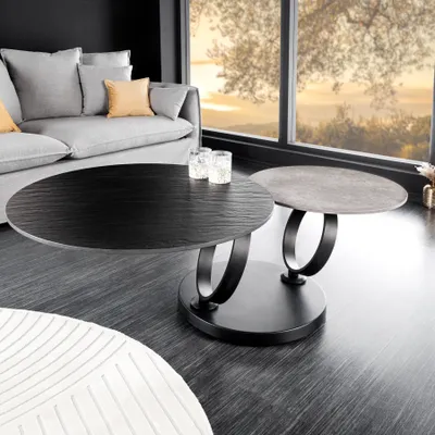 A modern living room with a sofa, coffee table, and a large window overlooking a scenic view.