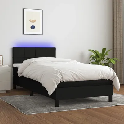 A black upholstered bed with a white duvet is shown in a room.