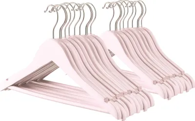A stack of light pink wooden hangers with silver hooks, neatly arranged.