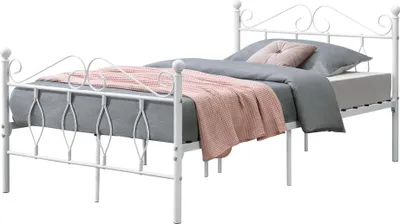 A white metal bed frame with a mattress, pillows, and a blanket.