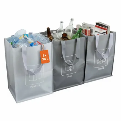 Three recycling bags for plastic, glass, and paper, filled with corresponding waste.