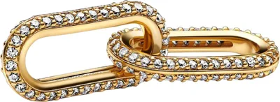 A close-up studio shot of a gold double link charm encrusted with small clear stones.