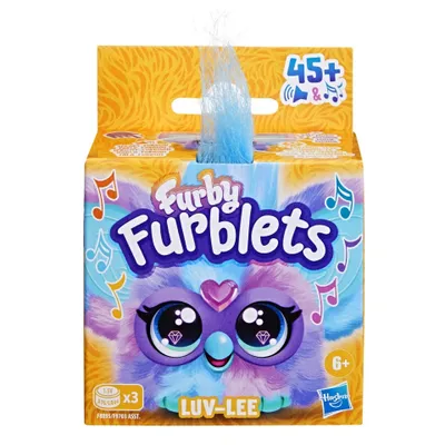 A Furby Furblets toy box with a blue Furby sticking out of the top.