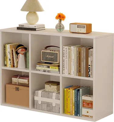 A white bookshelf filled with books, decorative items, and storage boxes.