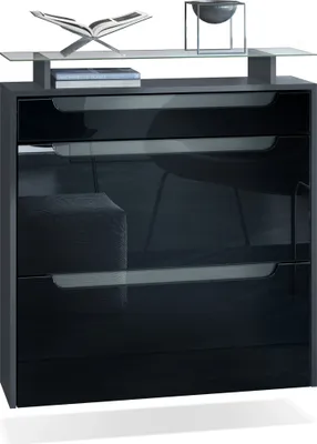 A modern, dark-colored shoe cabinet with a glass shelf on top, displaying decorative items.